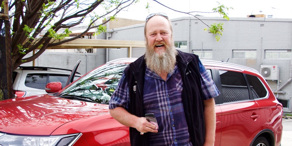man with beard in front of uber rental car